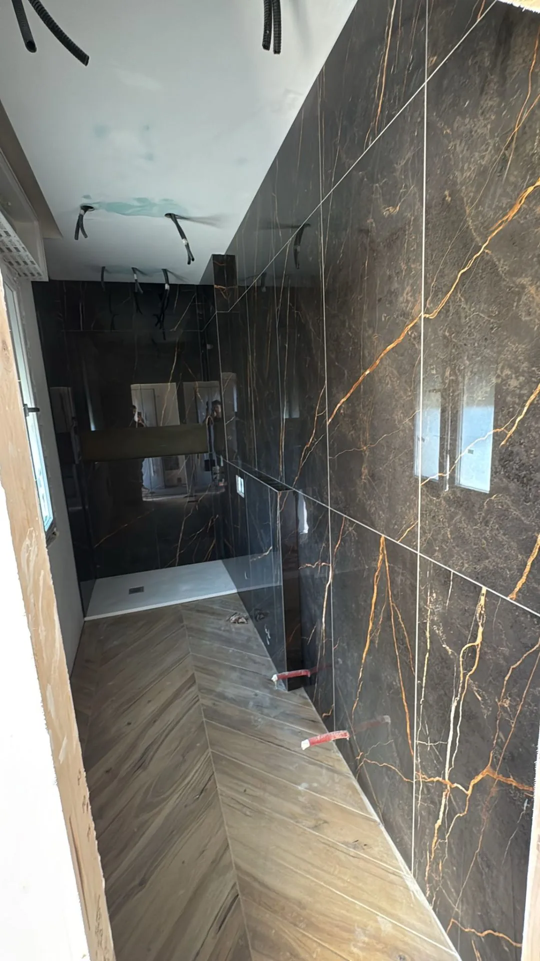Bagno effetto marmo nero Sahara Noir e parquet chevron — Ristrutturazione bagno a Modena