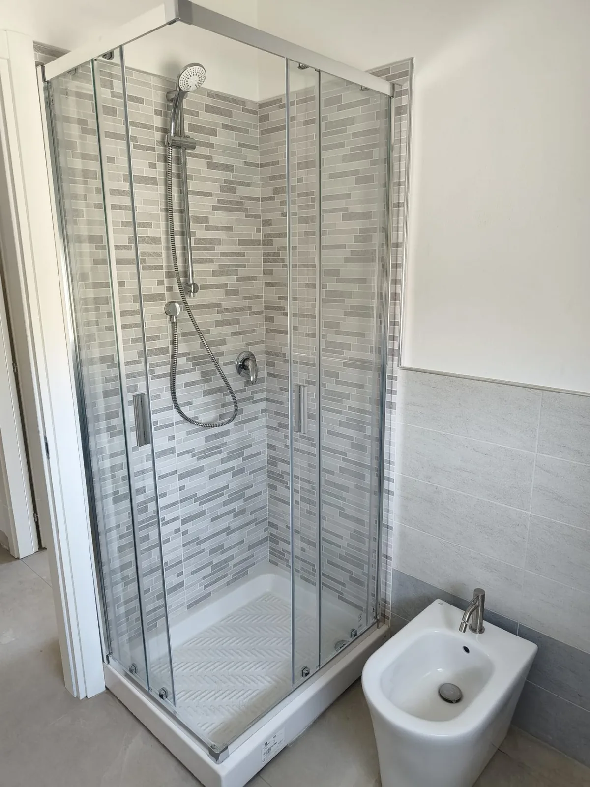 Bagno finito con doccia, mosaico e bidet sospeso — Ristrutturazione bagno a Modena