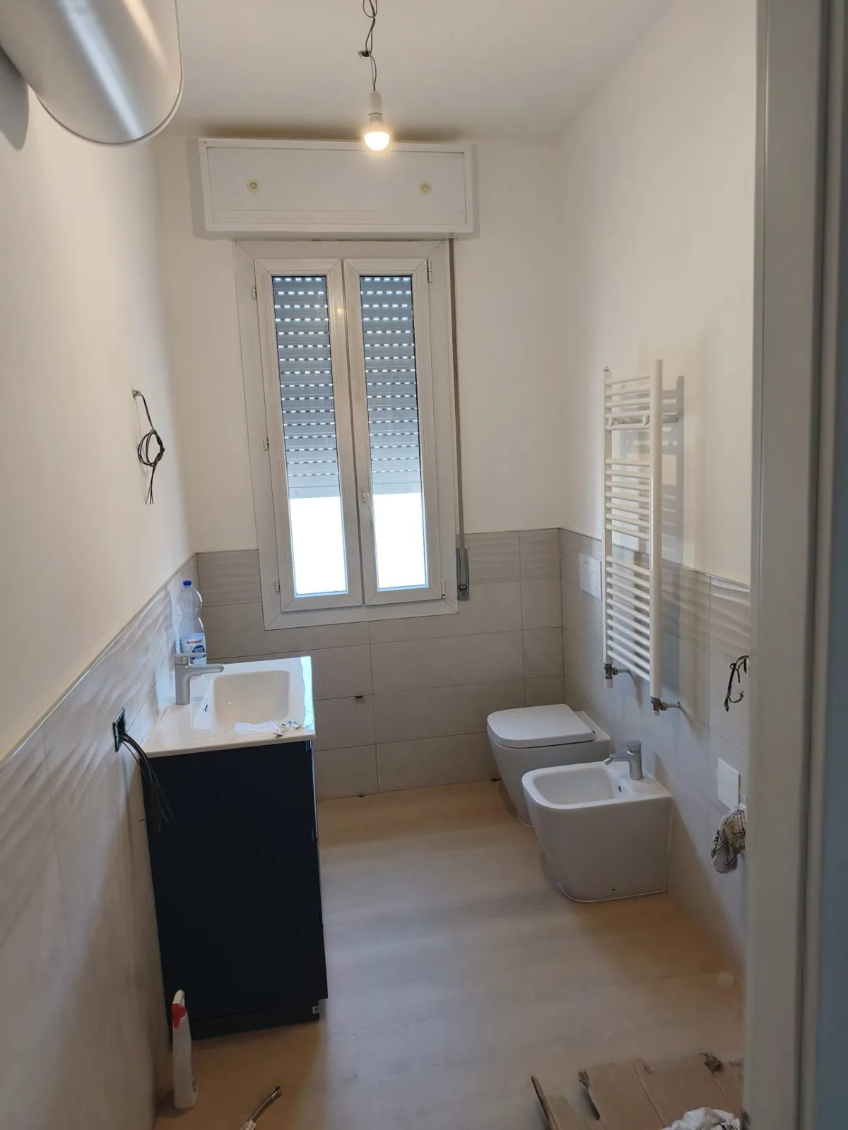 Bagno consegnato — Sanitari sospesi e termoarredo bianco — Ristrutturazione bagno a Modena