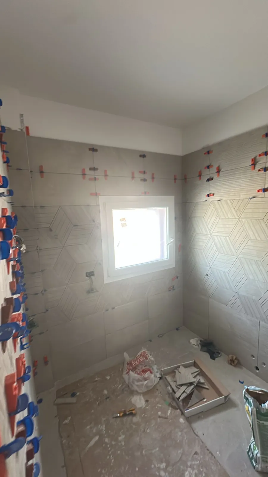 Bagno — Rivestimento a mosaico esagonale in posa — Ristrutturazione bagno a Provincia di Modena