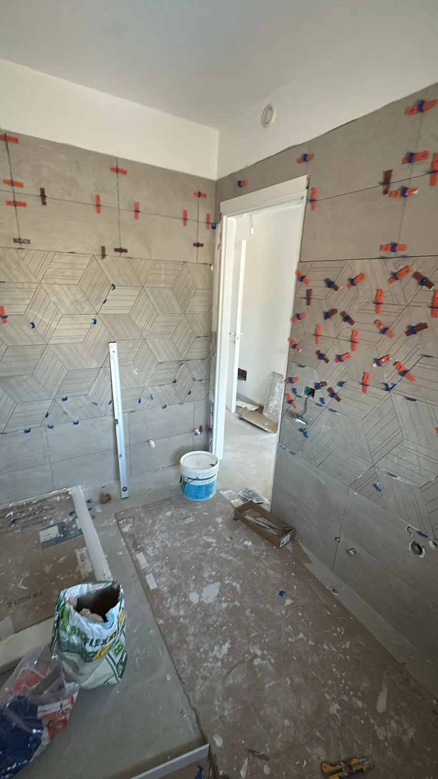 Bagno — Rivestimento in corso d'opera con clip di livellamento — Ristrutturazione bagno a Provincia di Modena
