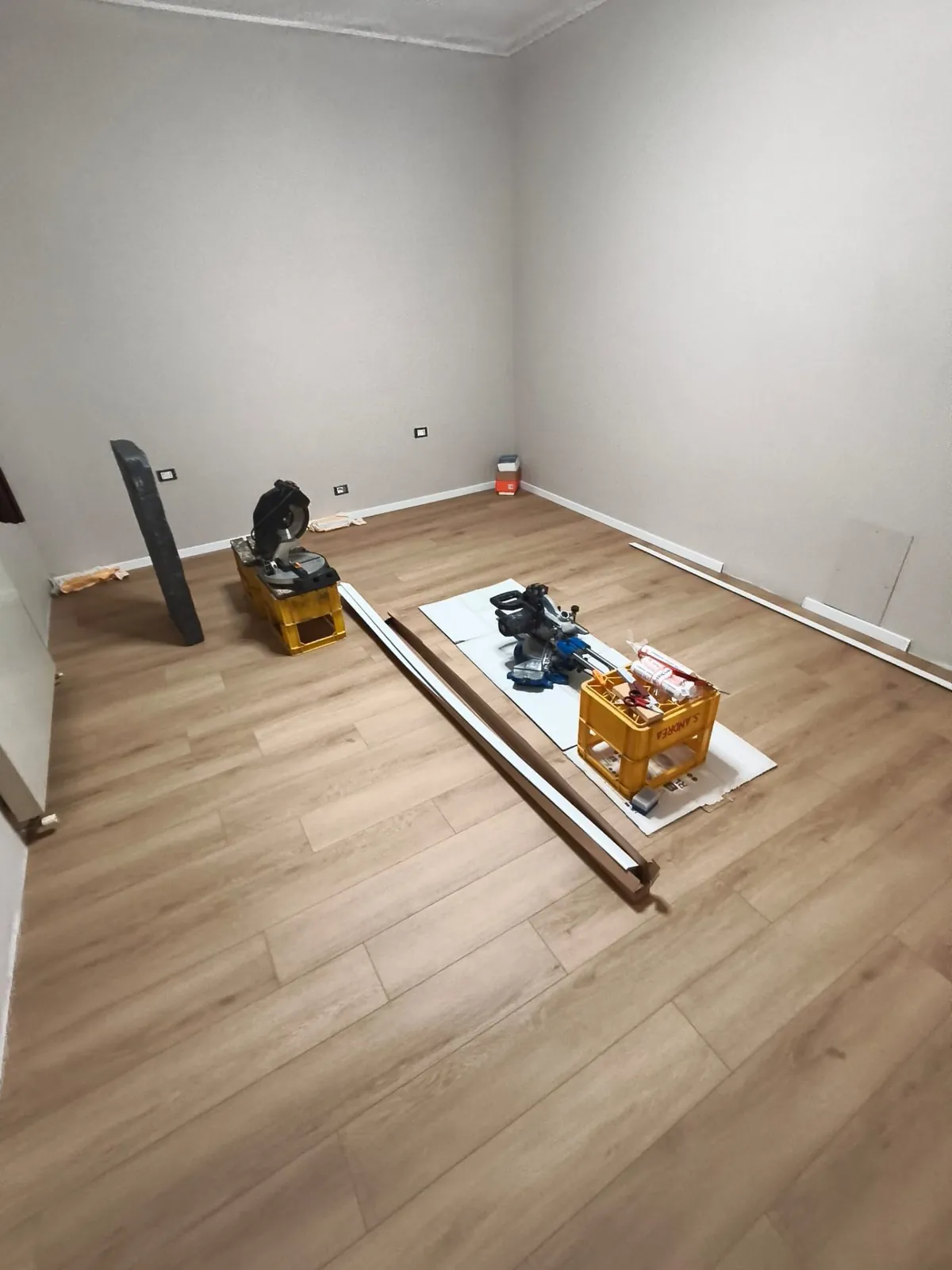 Camera — Cantiere posa battiscopa su parquet chiaro — Pavimenti a Modena