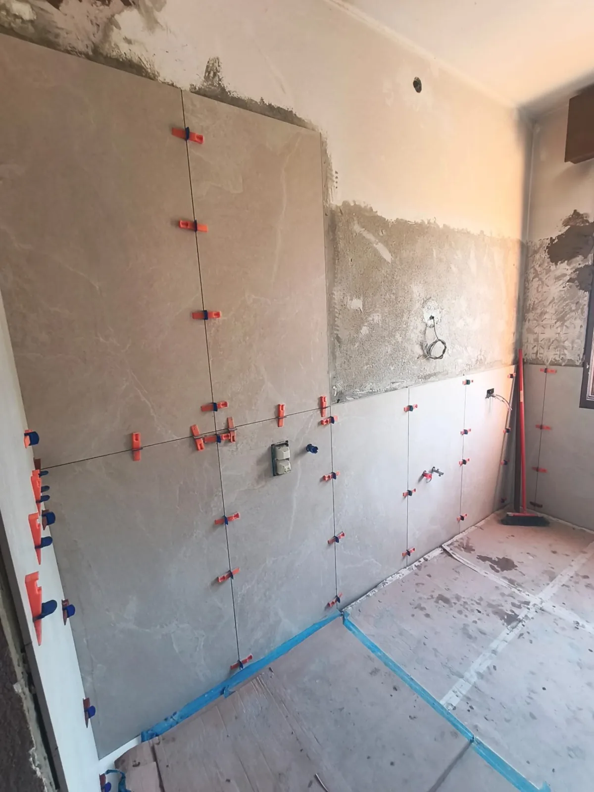 Bagno — Posa rivestimento effetto pietra con clip di livellamento — Ristrutturazione bagno a Modena