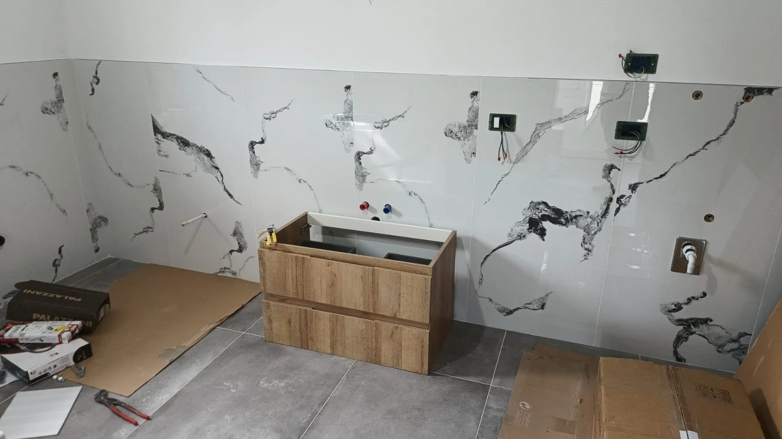 Bagno — Predisposizione miscelatori e scarichi su parete Statuario — Ristrutturazione bagno a Modena